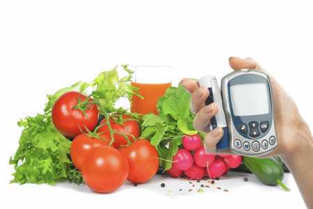 Глюкометр в руке и овощи