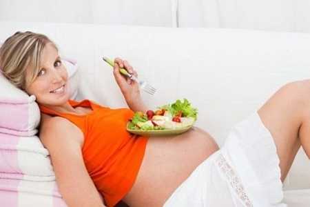 Беременная девушка кушает салат